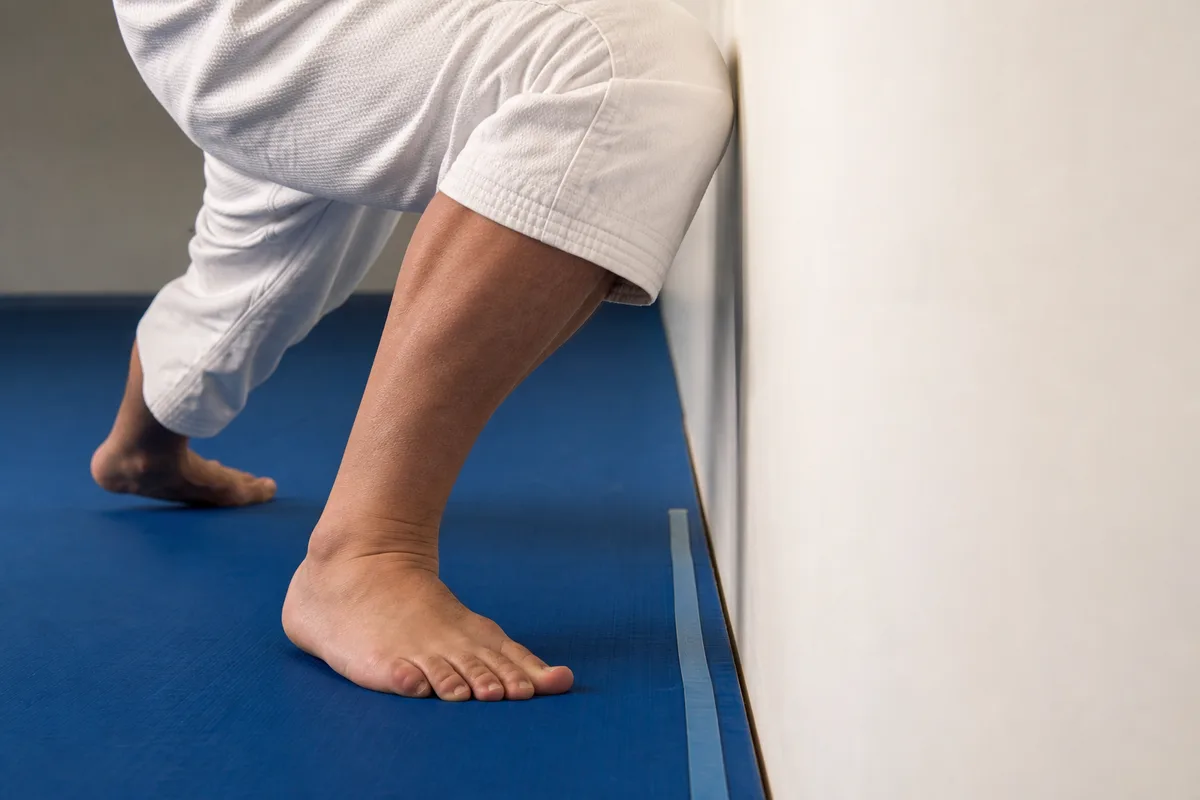 Test de flexion dorsale de cheville, genou vers le mur, dans un dojo